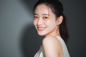 笑顔できらめく綺麗な肌と白い歯を見せる日本人女性美人モデルの接写写真。オーラルケア、スキンケア、コスメ広告用。