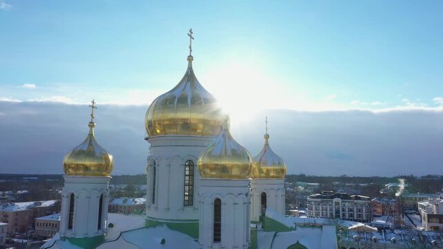 Bright sunburst shining behind the golden domes of Catherine Cathedral in snowy Pushkin winter landscape