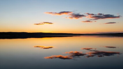 Naklejka premium Golden hour glow mirroring tranquil waters and serene sky at dusk creating a perfect reflective