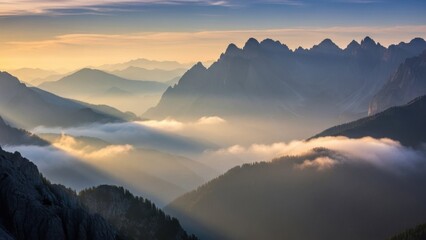 Majestic mountain range bathed in ethereal golden light at dawn with mist-filled valleys