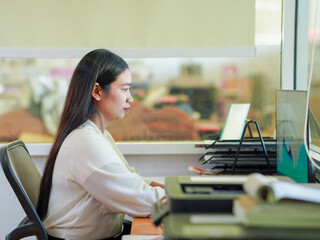 Candid business people using laptop and phone technology collaborative spaces at workplaces. Asian Businesswoman browsing internet working. Female leadership remote work goal planning new beginning 