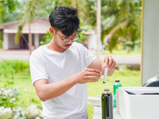 Asian man checking fertilizer vegetable hydroponics at home. People small business food farm. Healthy lifestyle crop ecology eco friendly for plantation and nutrition.
