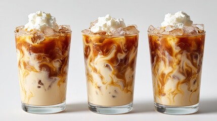 Three tall glasses of iced coffee topped with whipped cream and caramel drizzle