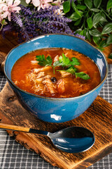 A stew with pieces of meat, sausage and mushrooms in tomato sauce.