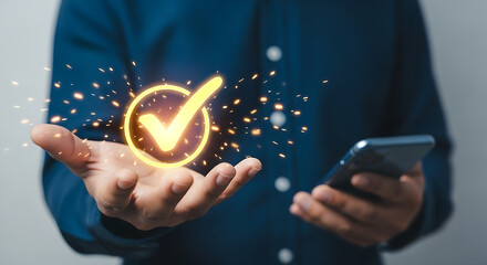 Man holding a glowing check mark and using a phone on modern blue background