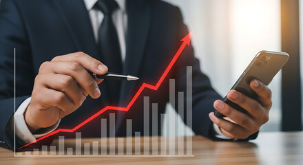 Man analyzing growth chart with pen and smartphone charting financial success