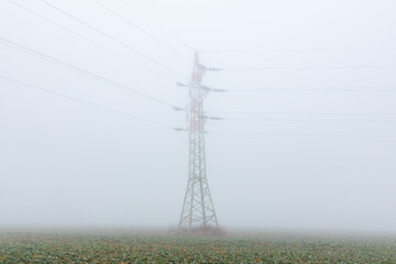 Electric wire tower in fog weather. Minimalism composition, distribution of power, simple industrial background