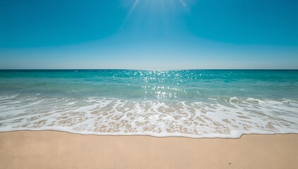 Waves washing over the sandy shore under a clear sky. A beautiful beach with turquoise water on a bright sunny day