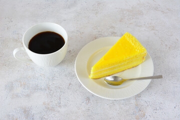 Delicious Yellow Cake Slice on white saucer and a cup of Coffee flat lay