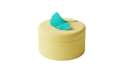 Isolated yellow container with turquoise ginkgo leaf decoration for cosmetics or accessories