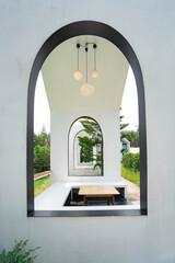 Minimalist White Archway Architecture with Repeating Arched Frames and Modern Pendant Lights