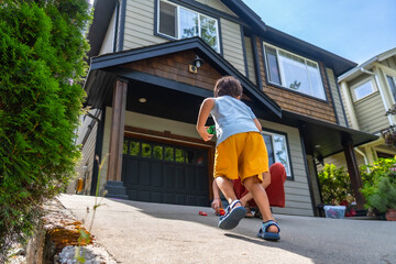Children playing with toy cars in front of their house