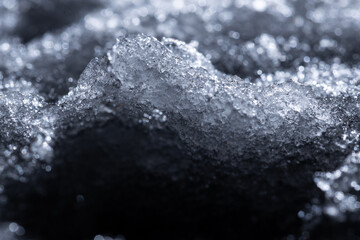 Snow and ice close-up on a dark background. Abstract winter background.