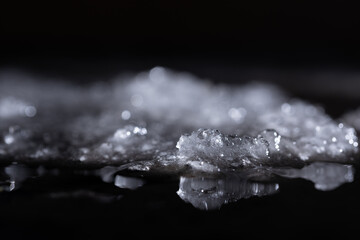 Snow close-up on a dark background. melting ice. 