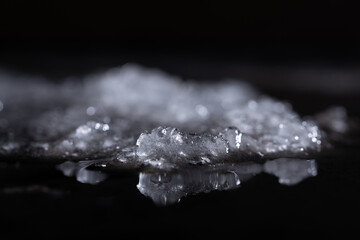 Snow and ice close-up on a dark background. Abstract winter background.