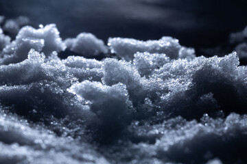 Snow and ice close-up on a dark background. Abstract winter background.