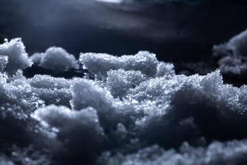 Snow and ice close-up on a dark background. Abstract winter background.