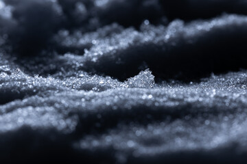 Snow and ice close-up on a dark background. Abstract winter background.