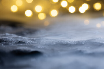 Close-up of snow and ice against a bokeh background. Abstract New Year's background.