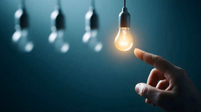 Hand touching glowing light bulb finding inspiration solution