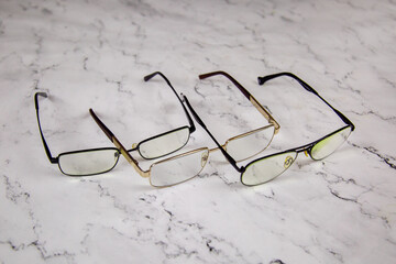 Glasses of various diopters on a gray marble table. Instrument, medicine, design, structures.