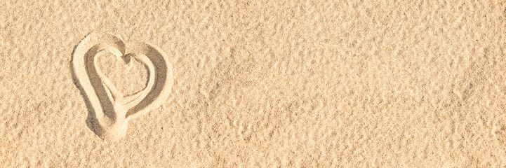 Sketch of a heart in the sand of a beach on panoramic background with copy space, summer beach holiday and romantic vacations web banner