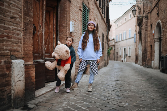 Mother and daughter explore picturesque street in Treia, Italy