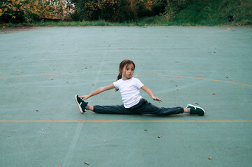 Young girl practicing gymnastic skills outdoors