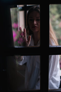 Woman silhouette touching window
