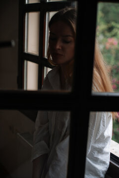Portrait of woman in contemplation by window