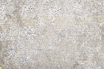 Abstract winter background featuring silver snowflake patterns and subtle glitter texture on a neutral beige surface, suitable for holiday design, seasonal themes, and decorative use.