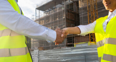 Engineers shaking hands at a construction site