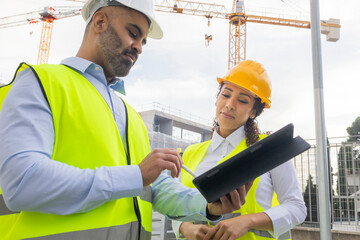 Engineers discussing blueprints at a construction site