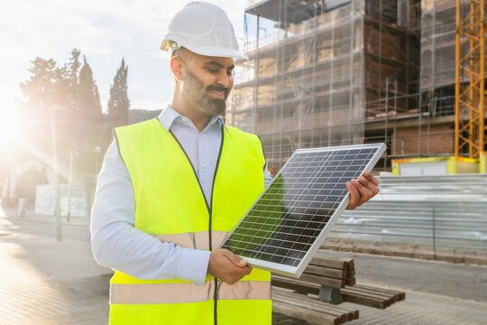 Engineer examining solar panel at construction site