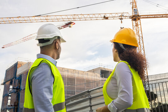 Engineers observing construction project site with cranes