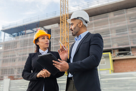 Engineers discussing project on construction site