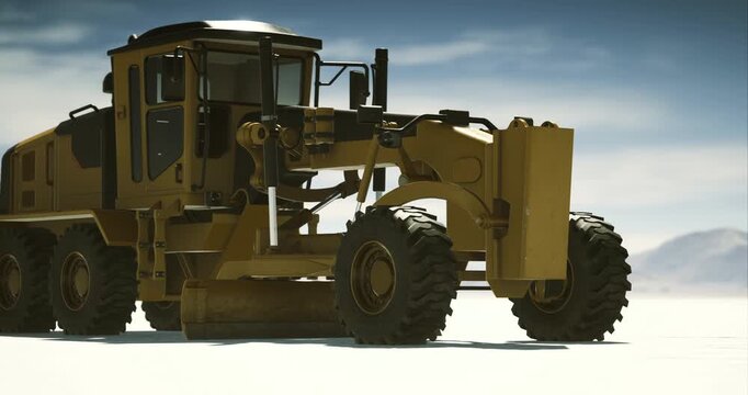 A yellow grader focuses on leveling the earth at a construction site during the day. Dust is kicked up as it carves through the ground, demonstrating its powerful presence and utility.