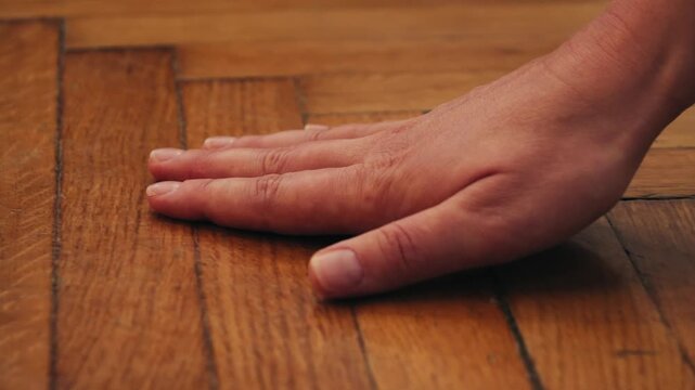 Hand touch oil finished oak wood surface, close-up of a wooden parquet floor, A hand touches the wooden surface, checking the quality of the material. High quality 4k footage