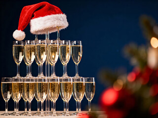 Festive Champagne tower with Santa hat on blue background