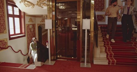 Business team meeting up in a traditional hotel lobby. They greet each other and discuss work.
