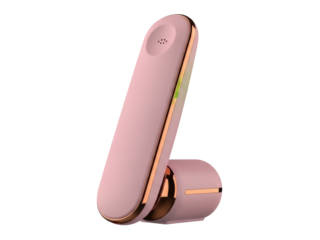 Isolated telephone handset for business in pink and gold, resting on its charger stand