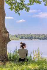 Fototapeta premium Woman Relaxing by a Tranquil Lake