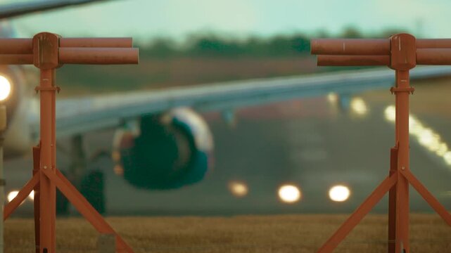 Airplane warming turbines and starting takeoff roll on runway. Jet powering engines and accelerating on landing strip with visible heat waves under clear sky. Airliner running turbines and beginning