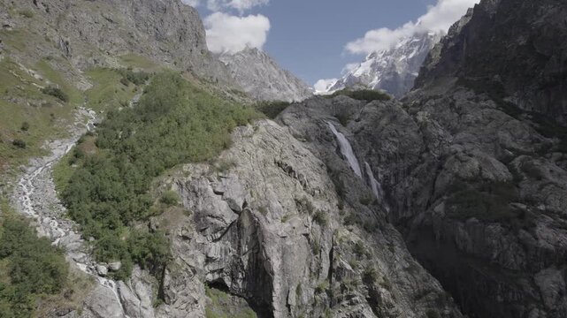 Aerial panorama of Shdugra Waterfall in the Dolra River valley, surrounded by the high Caucasus mountains in Svaneti, Georgia