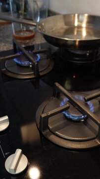 Turning on gas stove burner &mdash; close-up vertical video of kitchen cooking preparation. 9:16