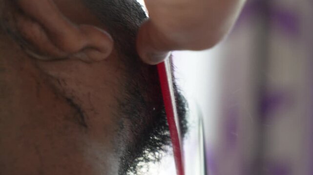 Barber trimming and shaping goatee