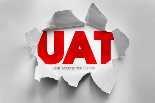 UAT acronym for User Acceptance Testing presented through a torn paper design, representing final phase of software testing where end users validate if the system meets business requirements