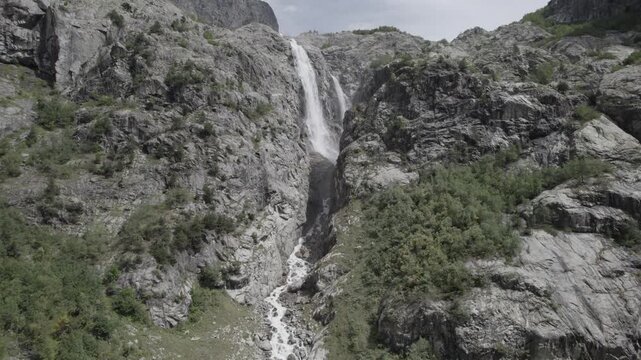 Aerial panorama of Shdugra Waterfall in the Dolra River valley, surrounded by the high Caucasus mountains in Svaneti, Georgia