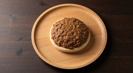 A circular bread base topped with a savory, textured, brown topping