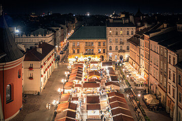 Christmas market with illuminated stalls at night on the Small Market Square in Krakow, Poland
